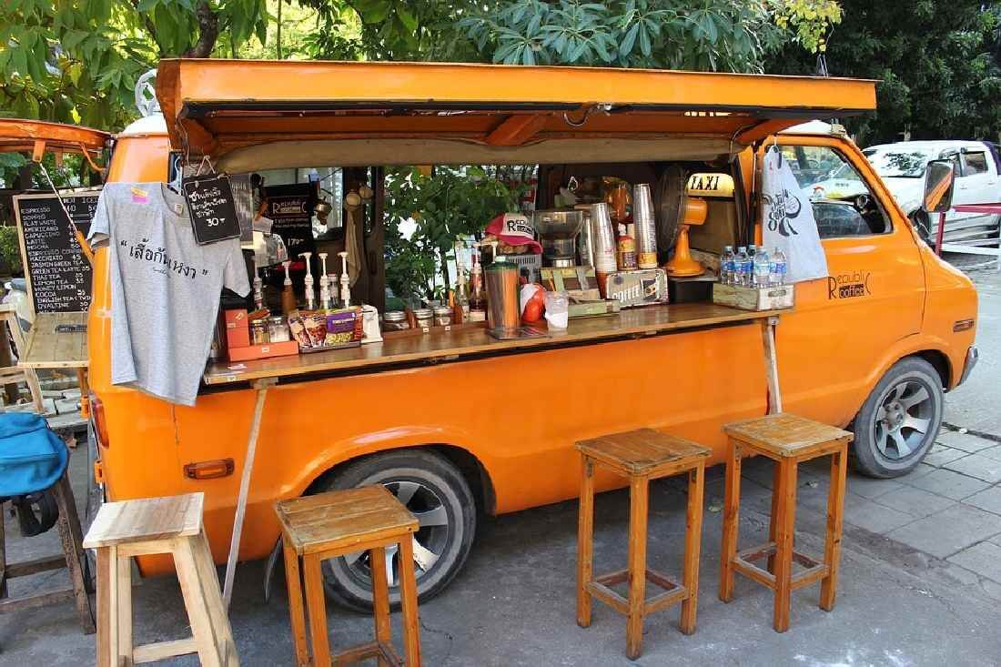 Oranger Food Truck mit Stühlen